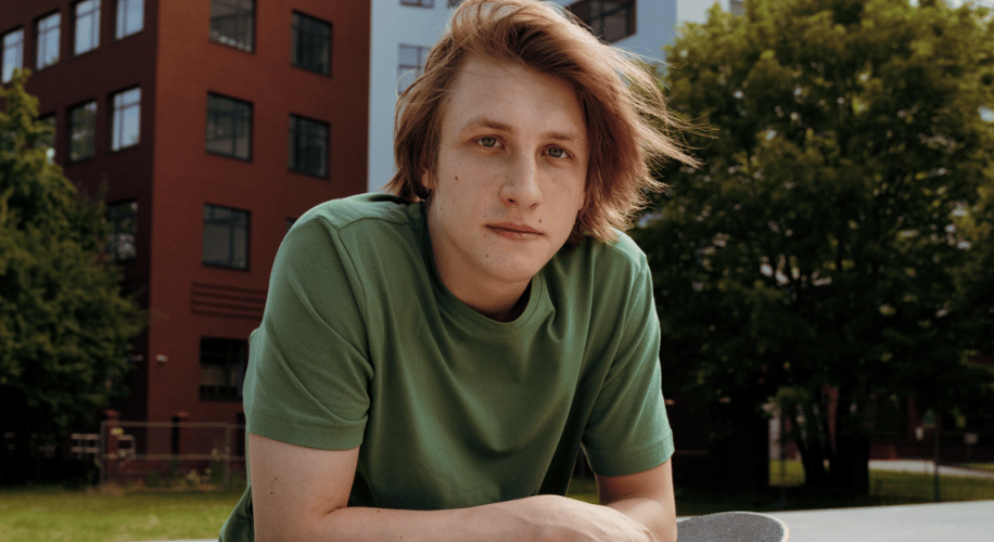 Portrait photo of a young man in front of a building