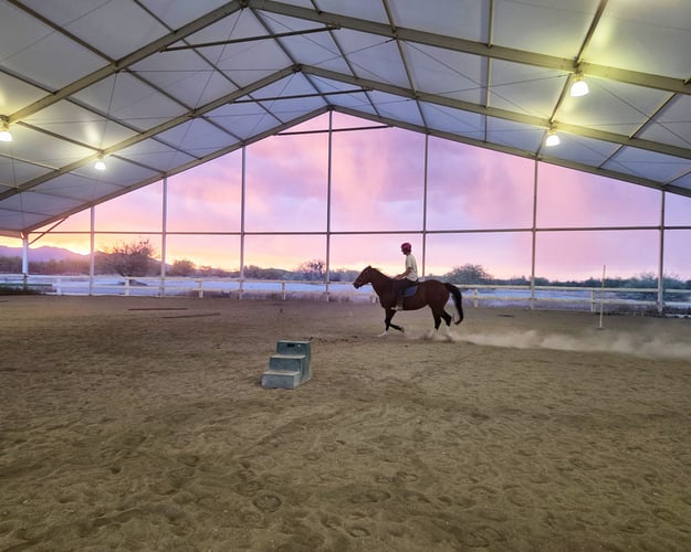 teen riding a horse at dusk