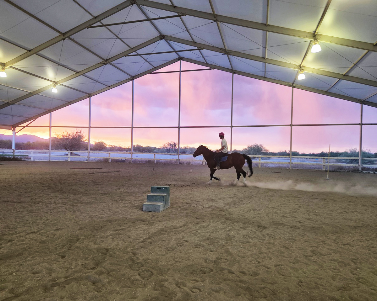 teen riding a horse at dusk
